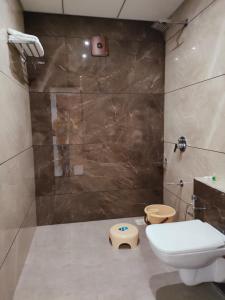 a bathroom with a shower with a toilet and a sink at HOTEL THE GRAND DIPAK in Junagadh