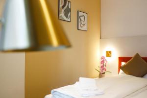a bedroom with a bed with white sheets and flowers at Boutique Hotel Piazza Grande Locarno - Easy Self Check-In in Locarno