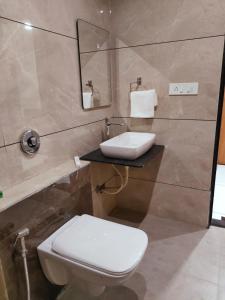 a bathroom with a toilet and a sink at HOTEL THE GRAND DIPAK in Junagadh