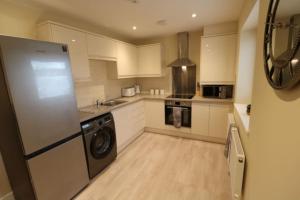 a kitchen with a refrigerator and a dishwasher at The Loft - IH21ALL - APT 9 in Thornaby on Tees