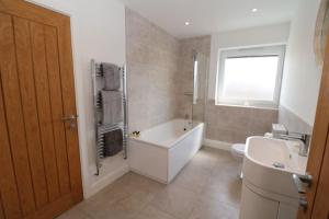 a bathroom with a tub and a toilet and a sink at The Loft - IH21ALL - APT 9 in Thornaby on Tees