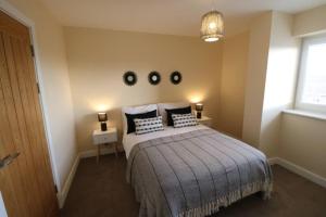 1 dormitorio con cama con almohadas y ventana en The Loft - IH21ALL - APT 9 en Thornaby on Tees