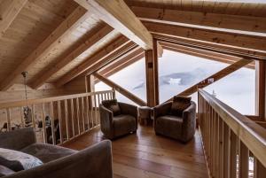 a living room with two chairs and a large window at Chalet Chocolat in La Tzoumaz +20 photos