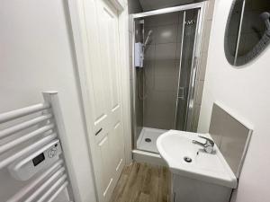 uma pequena casa de banho com um lavatório e um chuveiro em The Central Suite Sasco Apartments em Blackpool