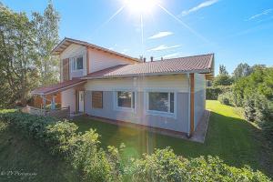 a small house with the sun shining on it at Stunning 5BR 16 Bed Home with Finnish Sauna & Jacuzzi 340 m2 in Tampere