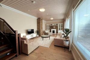 un ampio soggiorno con divano e TV di Stunning 5BR 16 Bed Home with Finnish Sauna & Jacuzzi 340 m2 a Tampere
