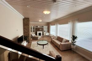 un soggiorno con divano e tavolo di Stunning 5BR 16 Bed Home with Finnish Sauna & Jacuzzi 340 m2 a Tampere