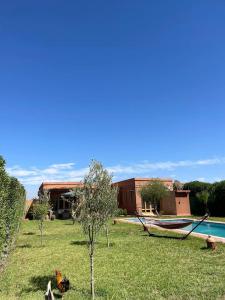 une cour avec une piscine, une maison et un arbre dans l'établissement Villa, piscine sans vis à vis et hammam privé., à Agadir Toudras