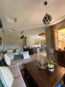 a living room with a couch and a table at Villa, piscine sans vis à vis et hammam privé. in Agadir Toudras