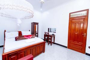a bedroom with a bed and a wooden door at Dodoma Shine Lodge in Dodoma