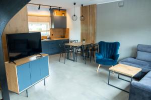 Baltic-Sand في Słajszewo: غرفة معيشة مع أريكة زرقاء وطاولة