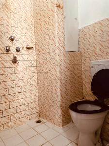 a bathroom with a toilet with a black seat at Hotel Discovery Inn in Kathmandu