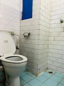 a bathroom with a toilet and a tiled wall at Hotel Discovery Inn in Kathmandu