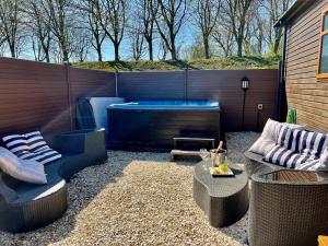 a patio with two chairs and a hot tub at Stags Head Lodge in Felton