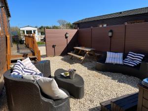 a patio with wicker chairs and a table and a bench at Stags Head Lodge in Felton