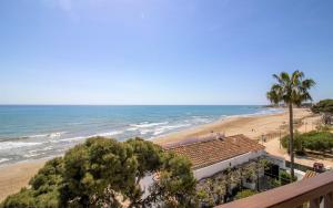a view of the beach from the balcony of a resort at Apartamento con vistas frontales - Primera línea Playa Cargador - ALBERT VILLAS in Alcossebre