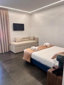 une chambre d'hôtel avec deux lits et un canapé dans l'établissement Outside Boutique Hotel, à Foggia