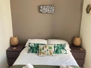 a bed with two pillows on it with two night stands at The Salt Box- Lovely refurbished annexe, free parking, walk to Porth beach. in Saint Columb Minor