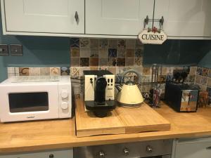 a kitchen counter with a coffee maker and a microwave at Dunster Luxe Nook in Dunster