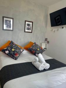 uma cama com duas almofadas e toalhas em Sun, Mountain & Adventure em Arad