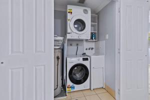 a laundry room with a washer and dryer at Zion Escapes Cairns City Waters Edge Family Apartment in Cairns