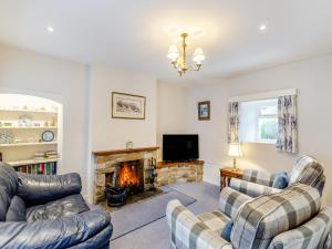 a living room with two couches and a fireplace at Victoria Cottage in Kettlewell