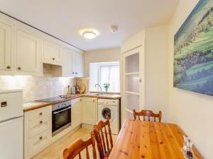 a kitchen with a wooden table and a dining room at Victoria Cottage in Kettlewell