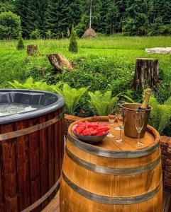 a barrel with a bowl of fruit and wine glasses at Casa Cifu Toplita in Topliţa