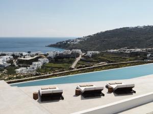 vistas a la piscina con tumbonas y al océano en Ezio Bo Luxury Living en Mykonos