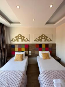 two beds in a hotel room with white sheets at Hotel Twenty in Antalya