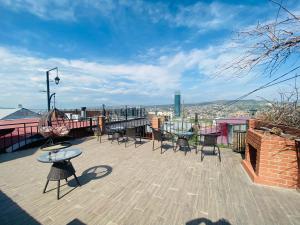 um pátio com mesas e cadeiras num telhado em 9 Borbalo Street Apartment with terrace em Tbilisi