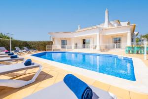 a villa with a swimming pool and lounge chairs at Villa Rose Bay by Algarve Vacation in Albufeira