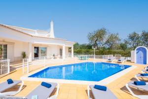 a villa with a swimming pool and lounge chairs at Villa Rose Bay by Algarve Vacation in Albufeira