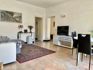 sala de estar con TV y mesa con sillas en Home Dolce Casa Apartment, en La Spezia