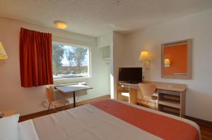 North Palm SpringsにあるMotel 6-North Palm Springs, CA - Northのベッド、デスク、窓が備わるホテルルームです。