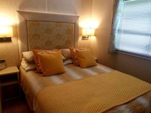 um quarto com uma cama com almofadas laranja e uma janela em Glan Hirfaen Where the mountains meet the sea em Porthmadog