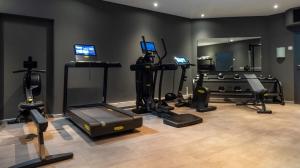 ein Zimmer mit einem Fitnessraum mit mehreren Geräten und einem Spiegel in der Unterkunft ibis Styles Berlin Treptow in Berlin