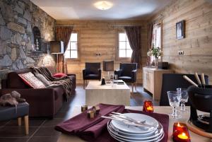 a living room with a couch and a stone wall at CGH Résidence Boutique La Grange aux Fées in Valmorel
