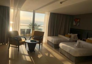 Habitación de hotel con cama y sofá en O Beach Hotel & Resort en Sowayma