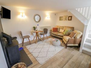 ein Wohnzimmer mit einem Sofa und einem Tisch in der Unterkunft The Little Cottage in Banbury