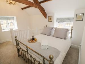 a bedroom with a bed with a tray of fruit on it at The Little Cottage in Banbury