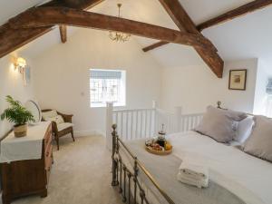 ein Schlafzimmer mit einem Bett, einem Tisch und einem Stuhl in der Unterkunft The Little Cottage in Banbury