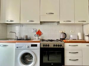 una cucina con fornelli e lavatrice di Home Dolce Casa Apartment a La Spezia