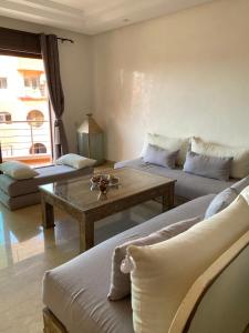 a living room with two couches and a coffee table at Résidence Las Palmeras in Marrakesh +1 photo