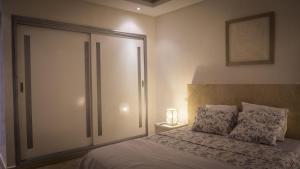 a bedroom with a bed with a sliding glass door at Résidence Las Palmeras in Marrakesh