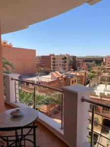 a balcony with a table and a view of a city at Résidence Las Palmeras in Marrakesh