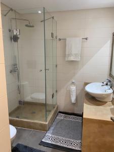 a bathroom with a glass shower and a sink at Résidence Las Palmeras in Marrakesh