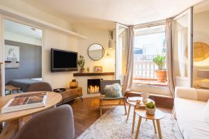 a living room with a couch and a table and a tv at Apartamento con terraza junto a Sol in Madrid