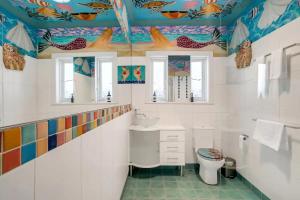 y baño con techo colorido, lavabo y aseo. en Harbourside Pad with Waterfront Views en Sídney