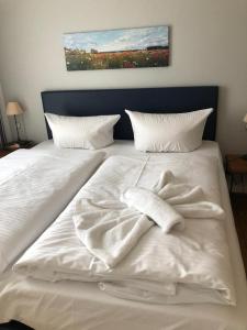a white bed with two towels on top of it at Ankerplatz Binz im Haus Strelasund in Binz